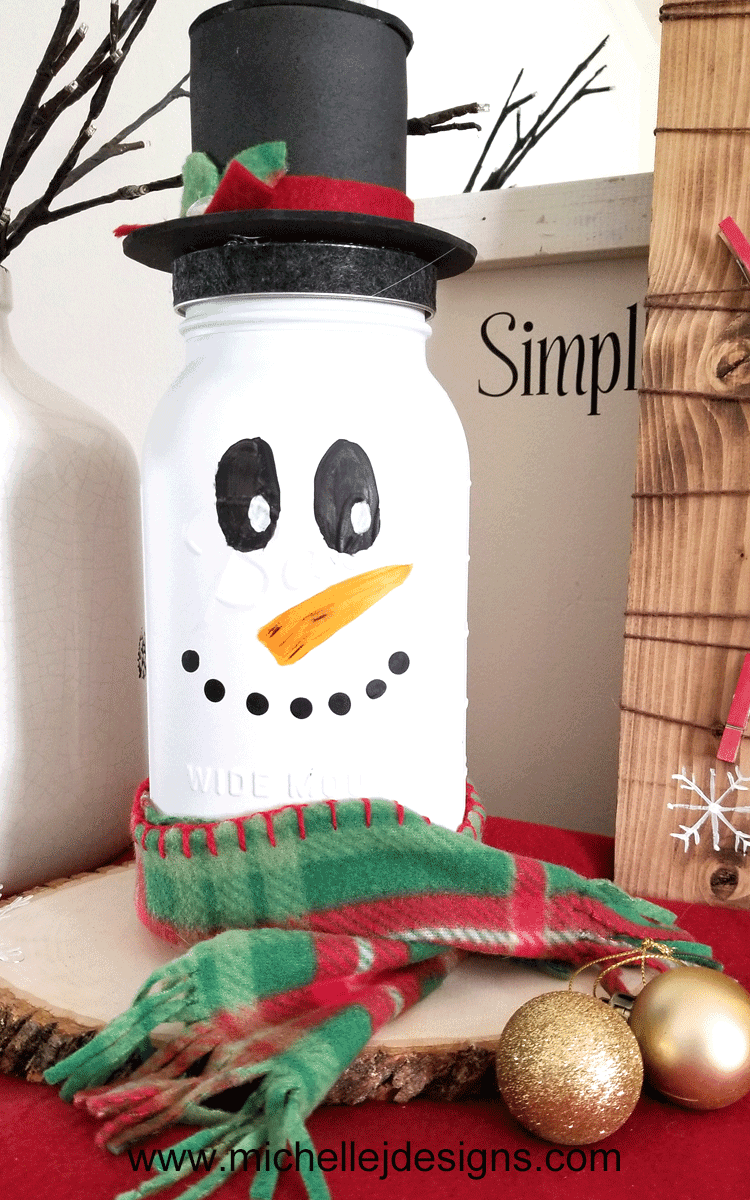 Take a look at my fun snowman mason jar craft. He is tall, festive and the perfect addition to my holiday decor. - www.michellejdesigns.com