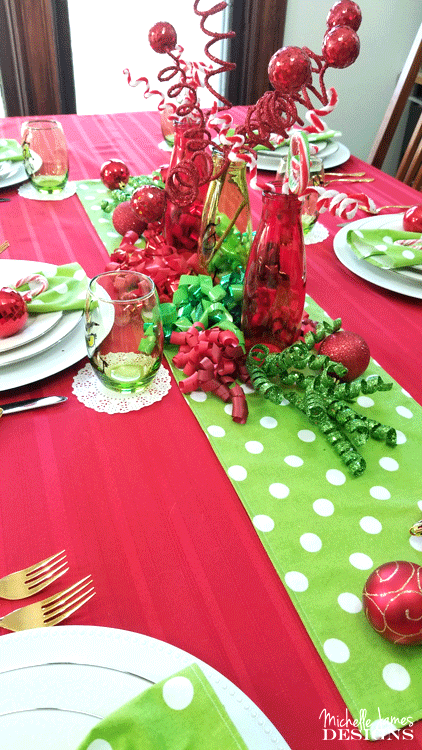 The table centerpiece with red and green fun Grinch inspired decor