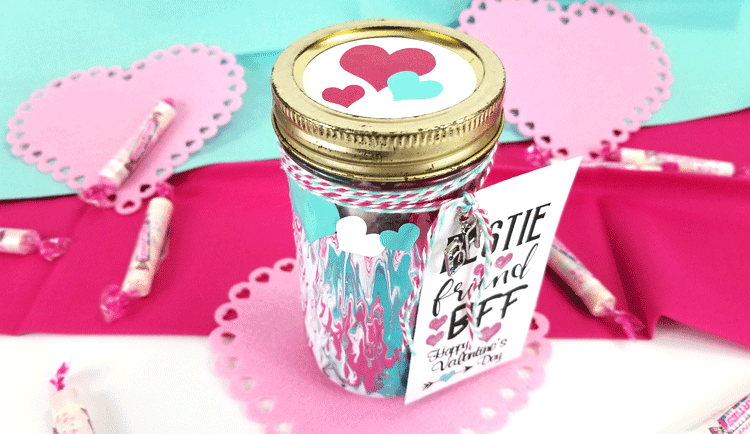Adding marbling medium to acrylic paints can make some really nice designs. This fun Mason Jar Valentine gift used this marbling with acrylic paint and it turned out awesome! - www.michellejdesigns.com #michellejdesigns #paintmarbling #silhouettecameo #masonjars #masonjargift