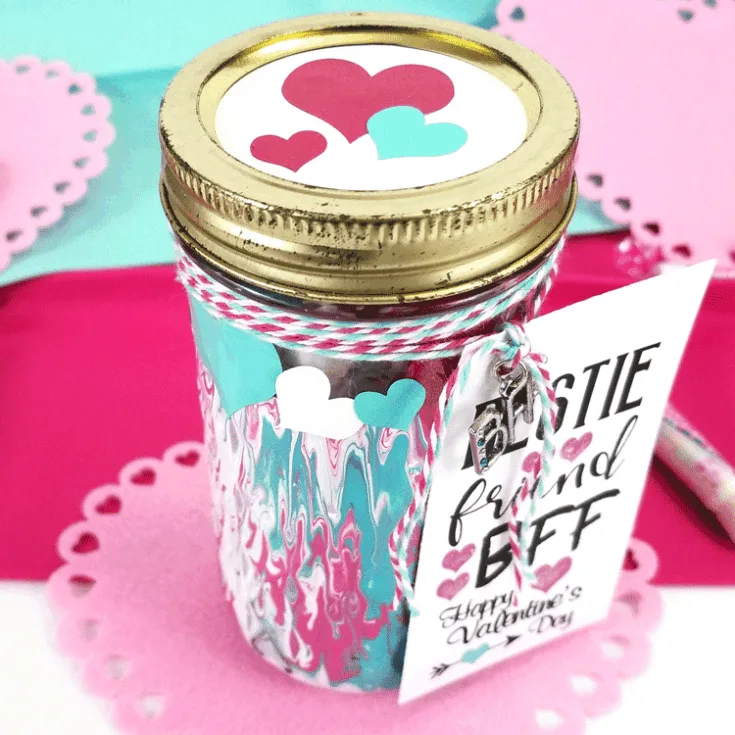 Adding marbling medium to acrylic paints can make some really nice designs. This fun Mason Jar Valentine gift used this marbling with acrylic paint and it turned out awesome! - www.michellejdesigns.com #michellejdesigns #paintmarbling #silhouettecameo #masonjars #masonjargift