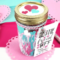 Adding marbling medium to acrylic paints can make some really nice designs. This fun Mason Jar Valentine gift used this marbling with acrylic paint and it turned out awesome! - www.michellejdesigns.com #michellejdesigns #paintmarbling #silhouettecameo #masonjars #masonjargift