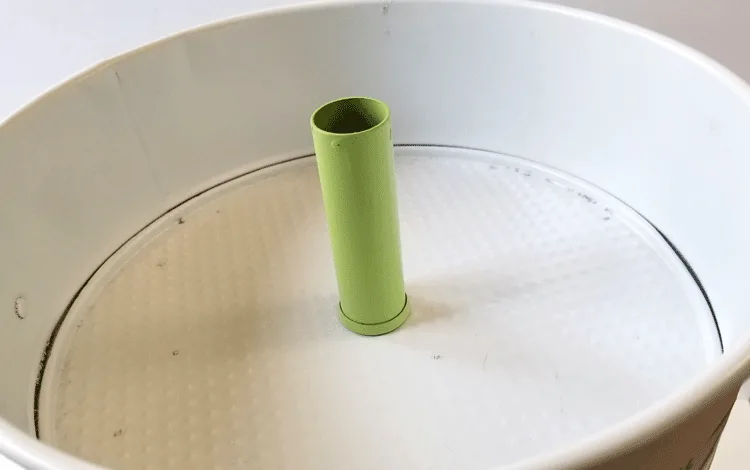 Top tier of tray with green tube piece to hold it together.