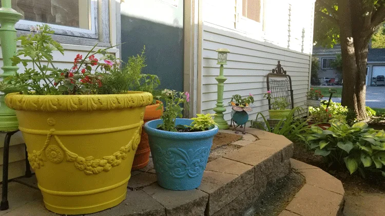 The three large foam planters by the backdoor with solar lamp posts in the background.