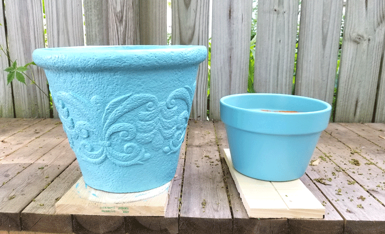 Teal painted foam pot and a smaller terra cotta pot. The two coats of paint make them look really nice.