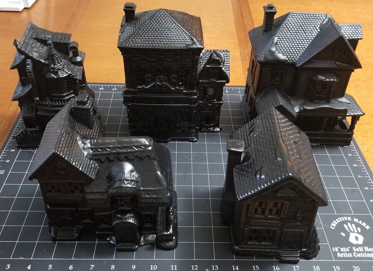 Christmas village pieces painted black to become a Halloween Village set.