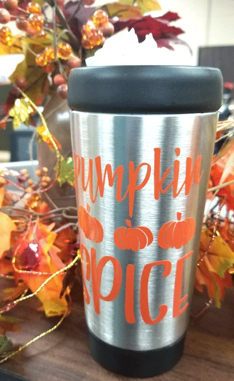 Travel mug with pumpkin spice latte and whipped cream