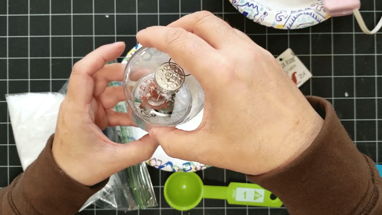 Adding the mason jar top over the mini ornaments and snow.