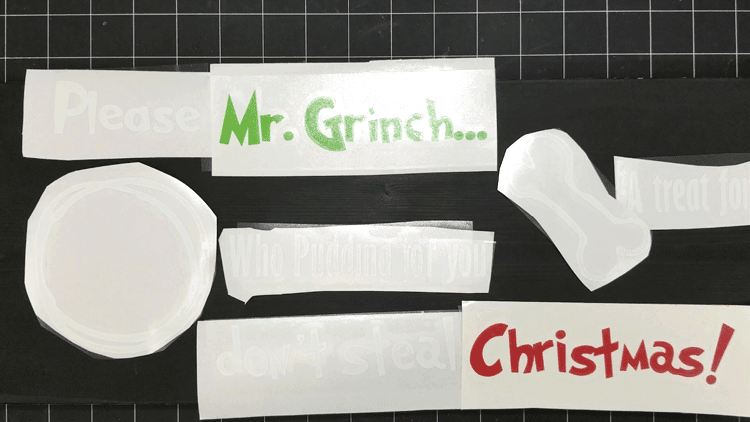 Laying out the design of cut vinyl on the Christmas Eve Grinch tray