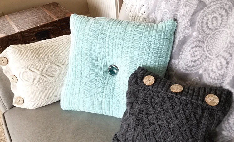 Finished sweater pillows displayed on a gray sofa