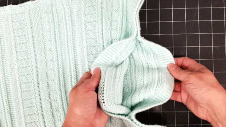 Turning the stitched sweater pillow inside out for finishing.