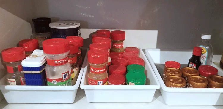 Drawer organizers used to organize spices in the kitchen cupboard