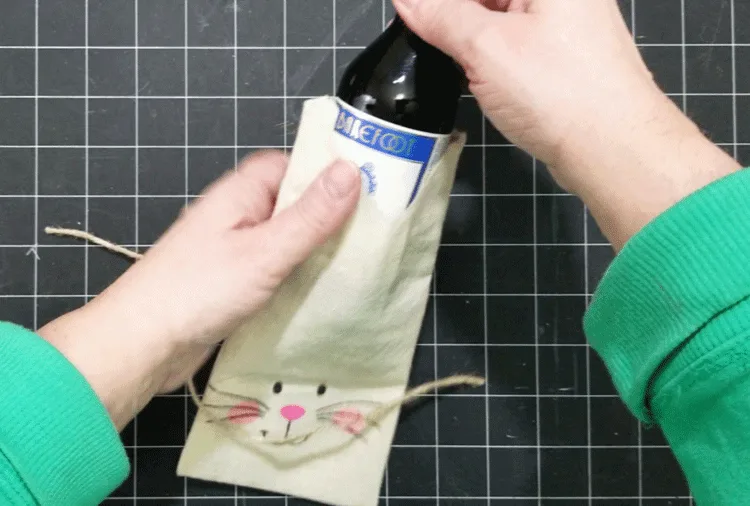 Adding a mini bottle of wine to a gift bag for adult Easter baskets