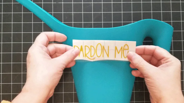 Adding vinyl to a plastic watering can for a garden gift basket idea