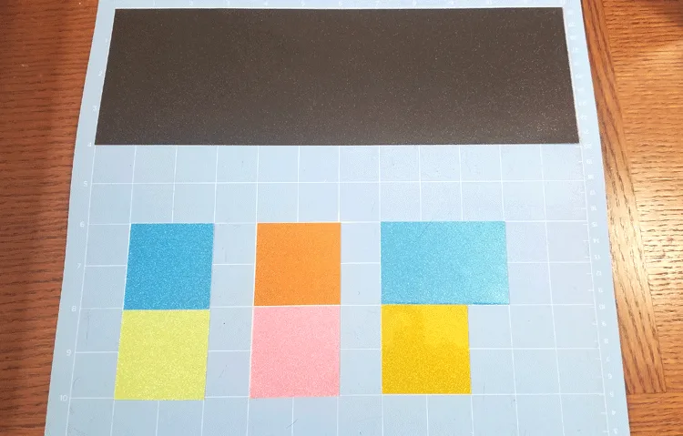 The different colors of transparent glitter vinyl laid out on the Cricut Mat ready to cut.