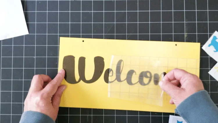 Removing the transfer tape from the Welcome text.