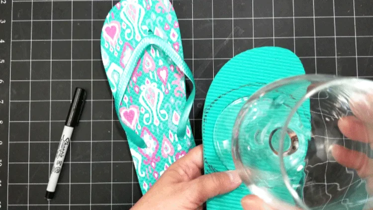 Holding up a stemmed wine glass and drawing a circle to cut out the coasters