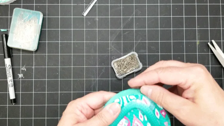 Using pins to attach the plastic straps to the Dollar Tree Flip Flop Coasters