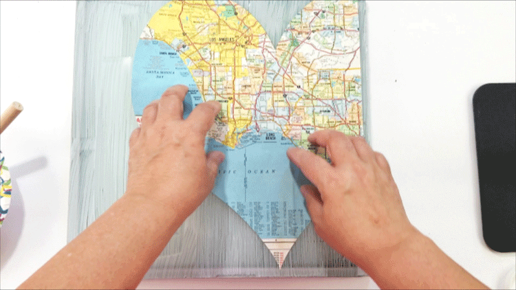Using Mod Podge to adhere the map heart to the back of the glass tile.