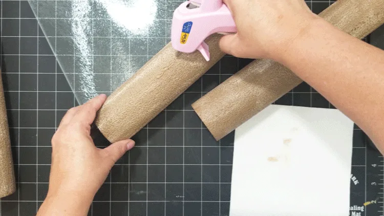 Using hot glue to glue the painted pool noodles together.