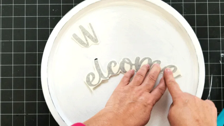 Adding the welcome text onto the pizza pan with brown vinyl