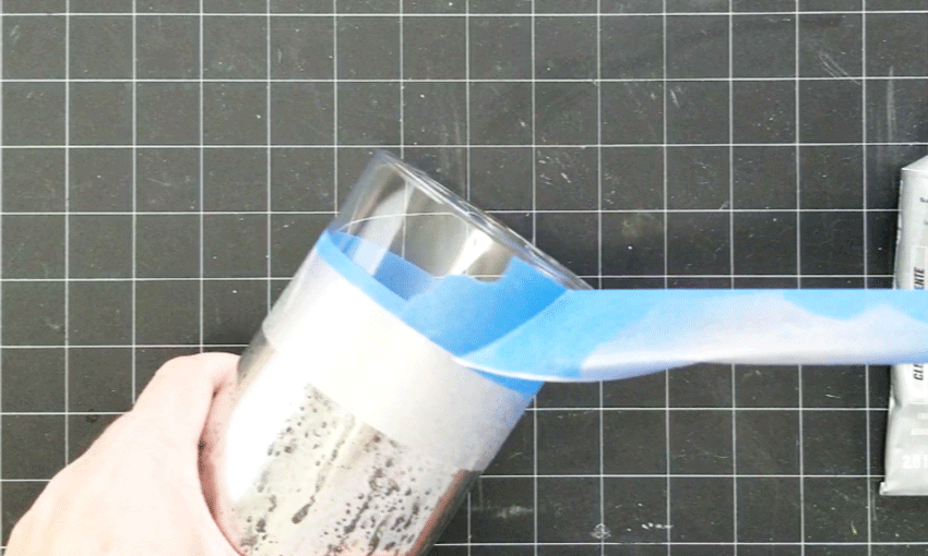Removing the painters tape from the top of the vase.