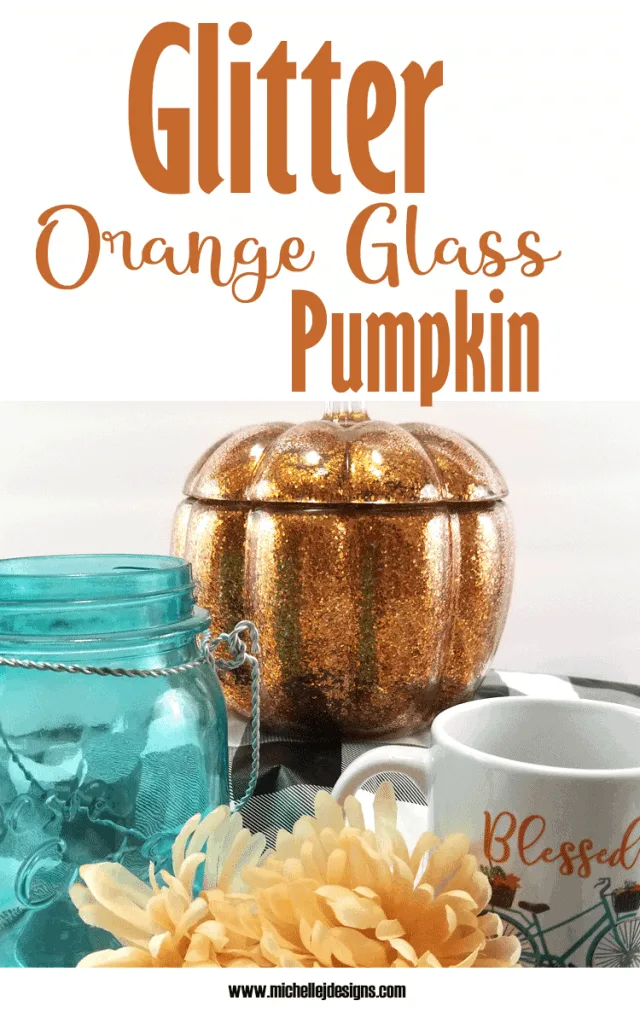 Finished glass pumpkin displayed with teal and orange decor.