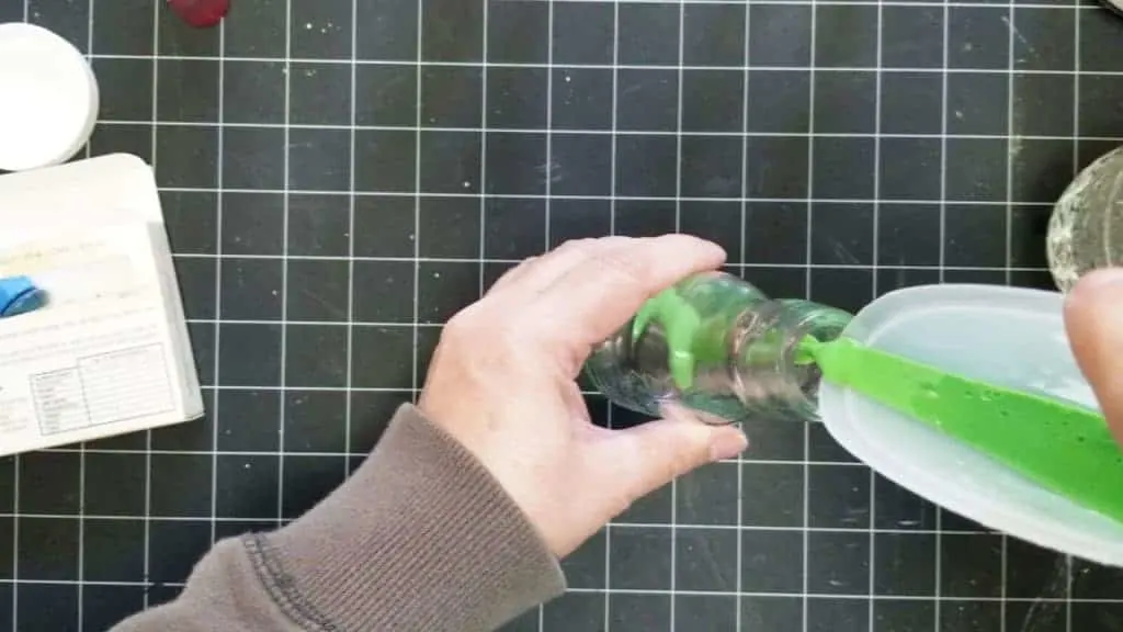 Pouring the color mixture into the bottle.