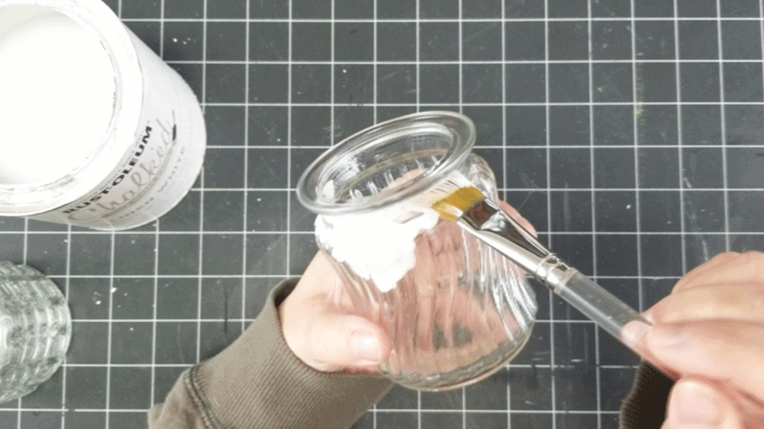 Painting the glass jars with white chalk paint.
