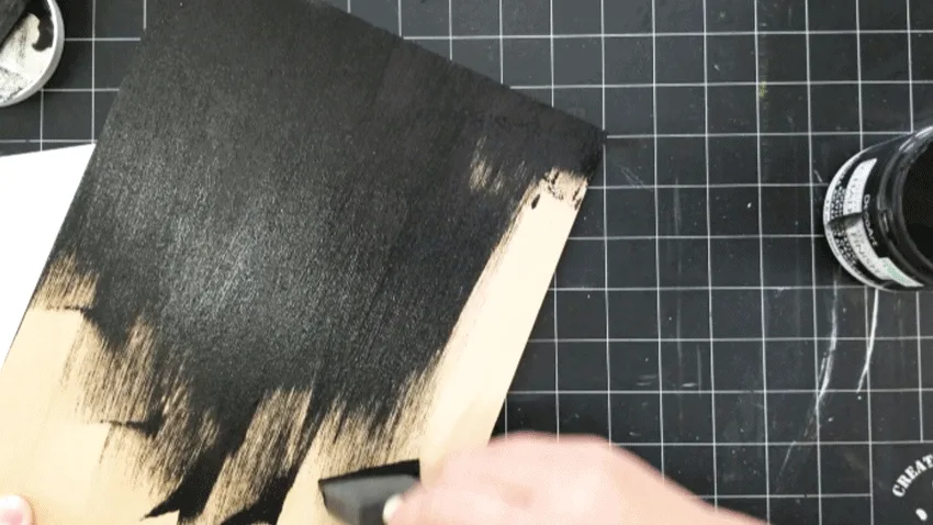 Painting the wood board with black chalk paint.- first coat