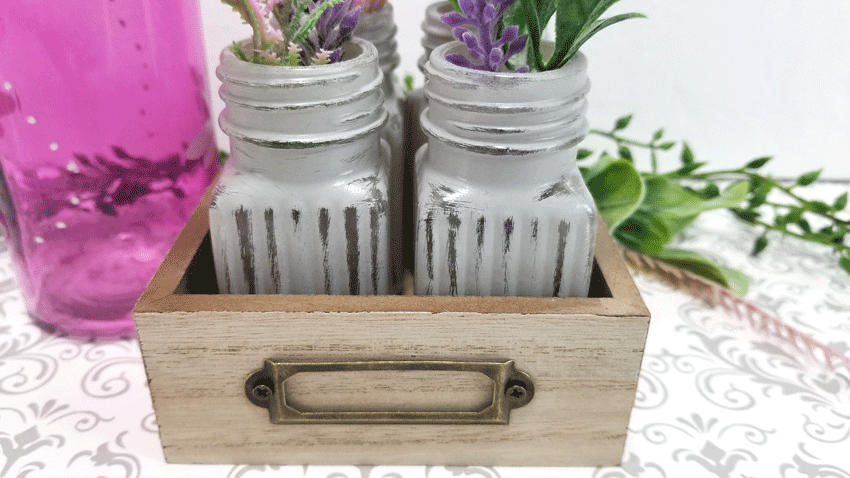 Close up photo of the chalk painted, distressed glass vases made from Dollar Tree salt and pepper shakers.