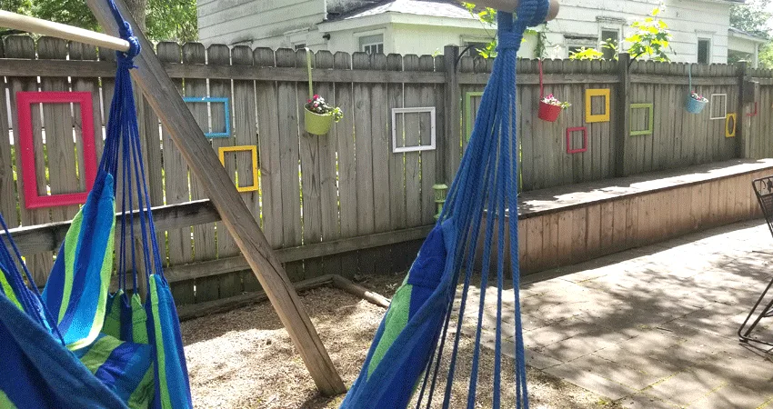 The finished fence with the hammock chairs.
