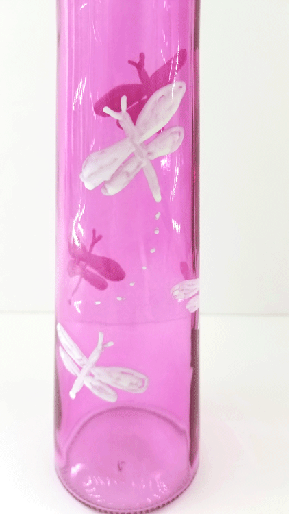 Drawing full dragonflies on the pink glass vases with oil based sharpie marker.