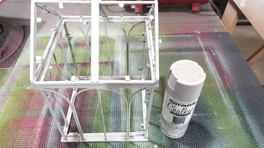Using the Rustoleum Chalked spray paint to paint the metal mini greenhouse
