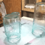 Spray painted glass jars after one coat of paint