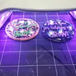 Using the UV light to cure the resin on top of the diy keychains