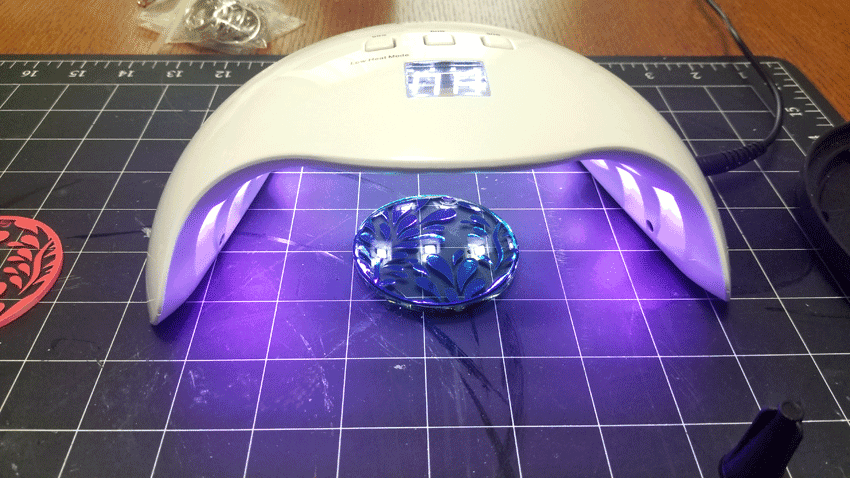 Using the uv light to cure the resin on the background.