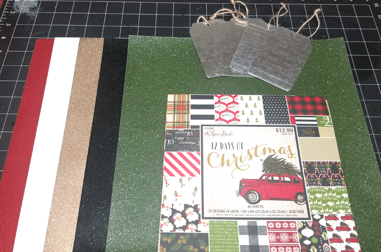 Supplies used to create the metal gift tags. Metal tags, Christmas paper and glitter vinyl.