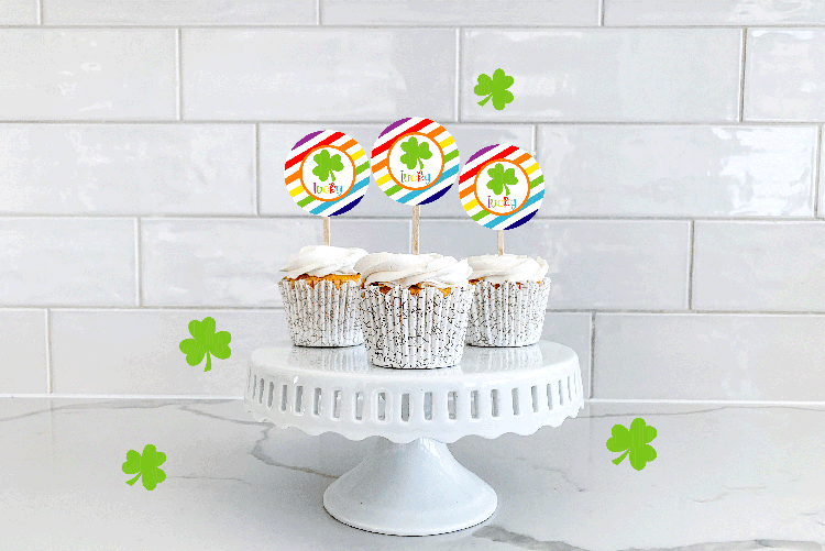 Three cupcakes on a stand with the cupcake toppers